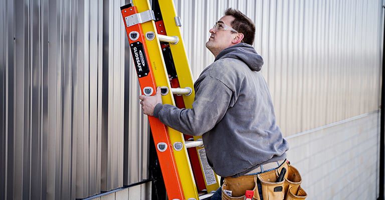 technicien qui utlise une échelle en fibre de glace 